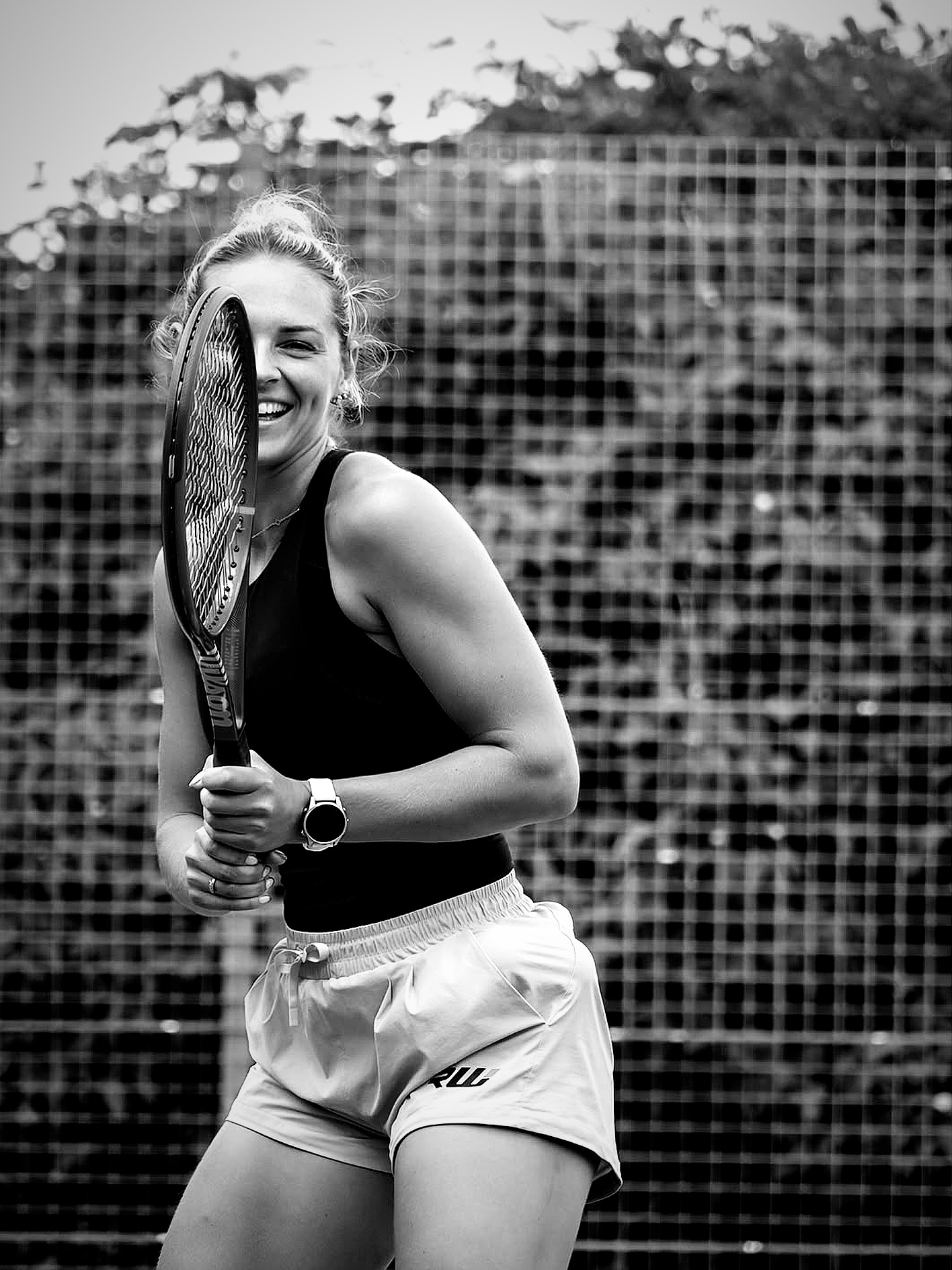 Black and white portrait of Taz smiling with a tennis racket